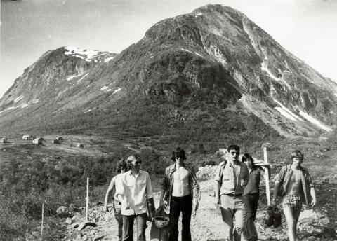 Bilete er frå ei synfaring i Grasdalen 26. juni 1973. Då var det enno ikkje avgjort om det skulle bli tunnel eller veg i dagen gjennom Grasdalen. Frå høgre ser vi Kolbjørn Nord, Tor Walaker, anleggsleiar Harald Ynnesdal, Arne Hool, Nils Dårflot og Arne Erdal. Me ser Skjerdingsdalen til venstre og Grasdalen til høgre. I bakgrunnen ligg Skjerdingsdal-setra.

