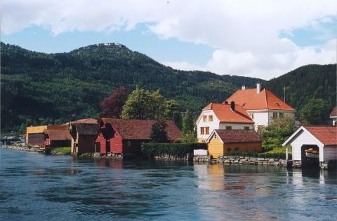 Perhustunet og Walhalla. Per den tredje sette opp dette vakre huset  i 1765. Her har det vore gjestgjeveri, tingstove og krambu. Her fekk folk i Nordfjord også kjøpa brennevin. "Skulen" er det kvite huset som står mellom hovudhuset og sjøen. I framgrunnen renn Stryneelva.
