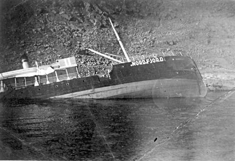 DS «Nordfjord» etter forliset 12. september 1940. Biletet viser skipsmerking i krigstid;  større bokstavar og markering midtskips, loddrett stripefelt i dei norske flagg-fargane.