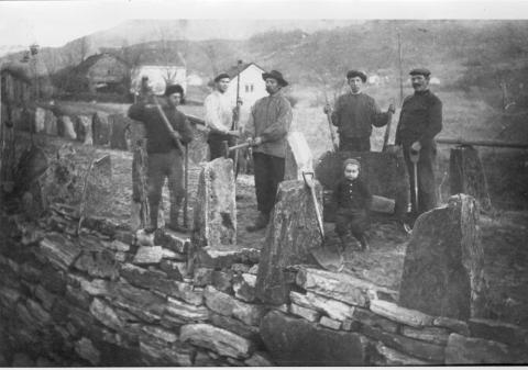 Arbeidslag på Naustdalsvegen. Frå venstre: Samuel Løken, Anders Åmot, Steffen Jonstad, Ola Reiakvam, og Karl Korgnes (?). Den vesle guten er Matias Veien. Veien heiter staden der fotografiet er teke. Veien ligg mellom Jonstad og Hove.  Men vegen var nok ikkje heilt tidsmessig då den stod ferdig. Biltrafikken sette nye krav til både vegbreidde og vegunderlag. Vegen måtte difor stadig utbetrast og utvidast. 