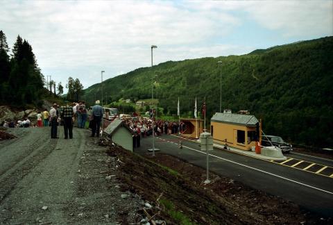 Frå opninga av Naustdalstunnelen 18. august 1995 ved bomstasjonen på Svarthumle. Samferdselsminister Kjell Opseth hogg av snora med øks. Det var møtt fram mykje folk som gjerne ville vera mellom dei første til å køyra den nye vegen.  


 