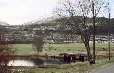 Slik såg det ut ved Sjøahola hausten 2001. Den gamle brua er her framleis, men det er stort sett det einaste som er ved det gamle. I bakgrunnen ser vi det nye sentrumet i Førde. Bak treet til høgre skimtar vi Øyrane Vidargåande Skule.
