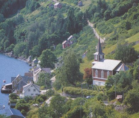 Randabygd kyrkje er fint plassert på ein avsats i bakkehellinga ned mot kaien i Randabygda.
