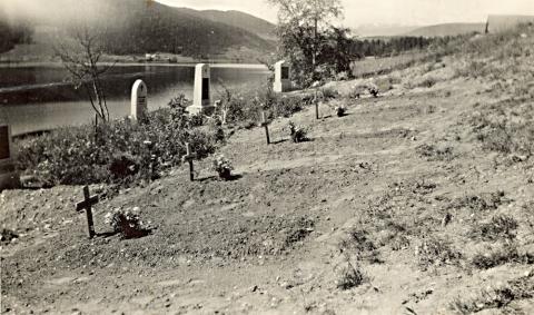 Biletet syner fem krigsgraver ved kyrkja i Aurdal våren 1940.
