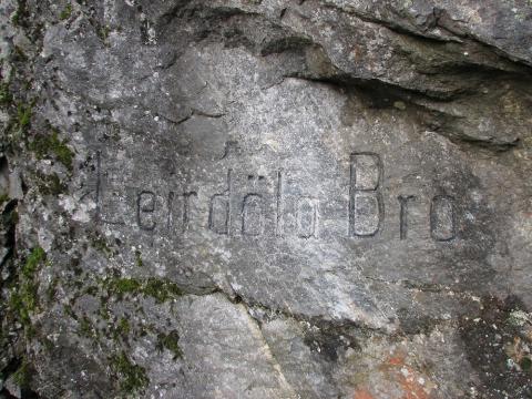 <b>Leirdøla Bro</b> står innhogge i berget ved det øvre brufestet til steinbrua bygd i 1906.