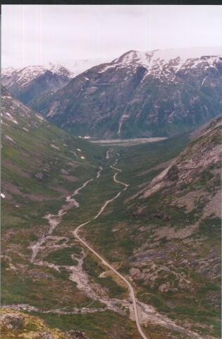 Sprongdalen sett nedover, eller sørvestover, mot Stordalen (øvste delen av Jostedalen) og Fåbergstøl-grandane. Vegen kryssar elva ved Viva (fremst i biletet), like etter staden der elva (eller den siklebakken som er att) frå sidedalen Sprongdalen kjem ned.