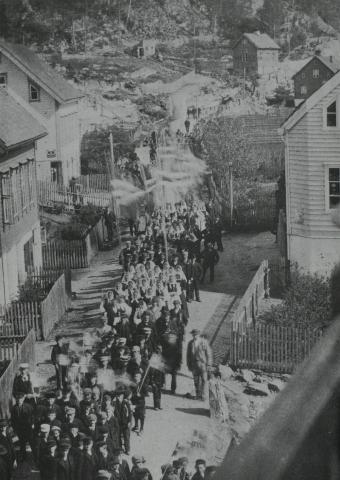 17. mai-toget på Sandane kring 1900. Bygdebladet "Norfjord" rapporterte: "Toget havde en anselig størrelse og tok sig meget godt ud med alle de nationalklædte jenter, med smaagutternes flag og foreningernes faner."