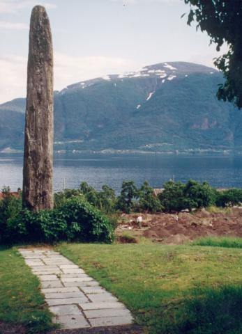 Baldersteinen i Leikanger, her sett mot søraust. Steinen står på privat grunn, tett attmed riksvegen, kring 500 m aust for kaien på Leikanger (Hanehaug). Det står opplysningsskilt ved riksvegen. Leikanger kommune har gjort avtale med grunneigaren om rett for allmenn tilgjenge. Biletet viser noko av utgravingsområdet då dei laga ny kyrkjegard i 1994.




