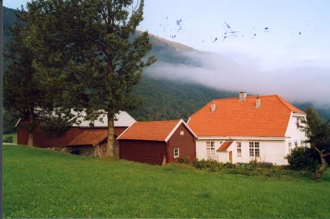 Lensmannsgarden med nokre av dei andre bygningane på garden, og eit stort tuntre. Tunet er velstelt og husa er haldne godt vedlike.