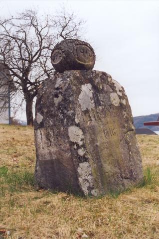 Minde-steinen er blitt litt skeiv med år og alder, og innskriftene er ikkje heilt lette å lesa lenger: ISC på den eine sida og MINDE 1816 på den andre.