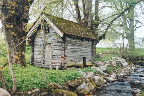 Eitt av dei to gamle kvernhusa som høyrer til prestegarden. Over døra er årstalet 1700 rissa inn.