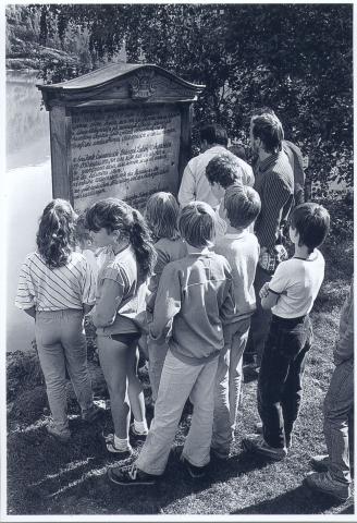 Frå avdukinga i august 1984. Elevar frå Bolstad skule ser på minnesmerket og universitetslektor Lars Steinar Hauge fortel og forklarar.
