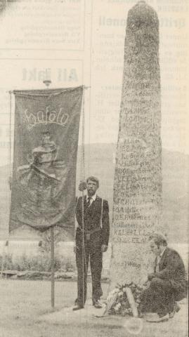 Hafslo Ungdomslag feira 90-årsjubileum i 1981. Ein av programpost var markering ved minnesteinen laget reiste i 1914. Formannen i laget, Leidulf Kvam, legg ned krans. Lars Karlsen held lagsfana.