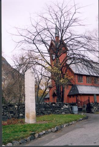 1814-steinen står like ved kyrkja på Tangen. Han er omlag 3 meter høg, prismeforma og kila ut or eit stykke lys granitt i Seimsdalen.