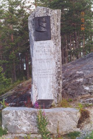 Ansiktsrelieffet i bronse er laga av kunstnaren Andreas Hauge. Det står innhogge:<br /> 
OBERST * RASMUS * HATLEDAL * 1885-1963 * GENERALSTABSJEF * 9. APRIL 1940 *<br /> 
FOR LANDET VÅRT * EI LAGNADSTID * MOT FRAMAND VALDSMAKT - BAUD DU STRID<br />
&lt;Merknad: stjerne (*) tyder: på ny line&gt;.
