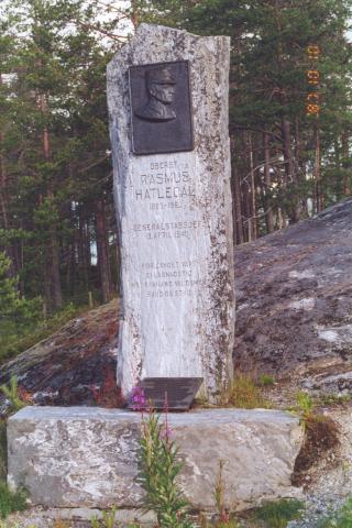 Ansiktsrelieffet i bronse er laga av kunstnaren Andreas Hauge. Det står innhogge:<br /> 
OBERST * RASMUS * HATLEDAL * 1885-1963 * GENERALSTABSJEF * 9. APRIL 1940 *<br /> 
FOR LANDET VÅRT * EI LAGNADSTID * MOT FRAMAND VALDSMAKT - BAUD DU STRID<br />
<Merknad: stjerne (*) tyder: på ny line>.
