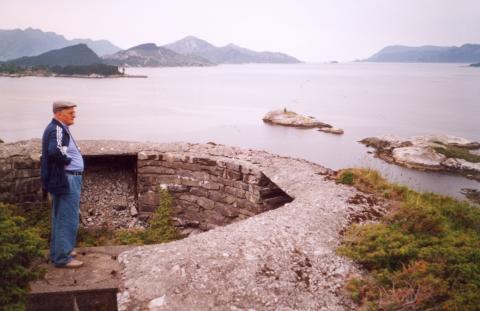 I 1994 var Bernhard Schaller tilbake på Tangane der han som 19 år gamal soldat opplevde Måløy-raidet. På biletet står han på fundamentet til luftvernkanonen han var mannskap ved under kampane. Han fortel flya kom innover fjorden, og sleppte bombene sine over fortet. Ei bombe traff rett framfor stillinga, og som ved eit under overlevde han, sjølv om uniforma også tok fyr.