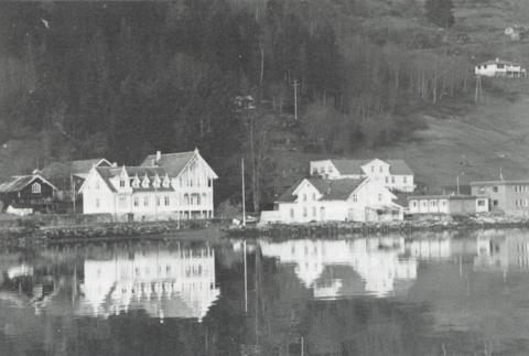 Døsen sett frå Lustrafjorden. Bygningane på kaien kjem klårt fram. Bak desse skimtar me våningshuset på garden Nygard.