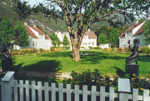 Grøntområde mellom husa der skulpturen "Maskeberere" av Hilde Mæhlum har fått plass i dag.
