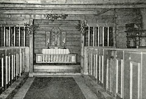 Frå interiøret i kyrkja, mot koret med alteret og altertavla. Altartavla er frå 1950 og er laga av Kåre Martinsen. Ho stod på alteret frå 1950 til 1977, men heng no på sideveggen i koret. Dørene til dei innebygde kyrkjebenkene er måla i raudt og grønt. På høgre sida i skipet står Korssundstolen, sjølve herrestolen i kyrkja.
